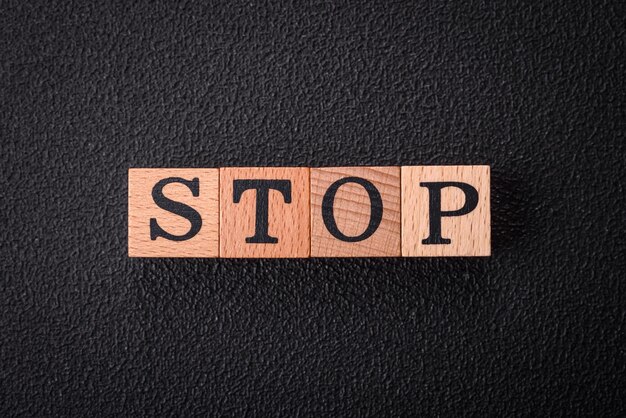 The inscription stop on wooden cubes on a dark concrete background