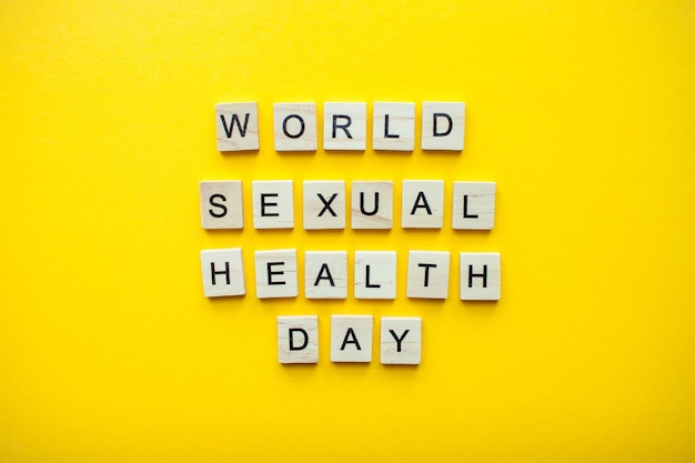 The inscription world sexual health day from wooden blocks on a bright yellow background