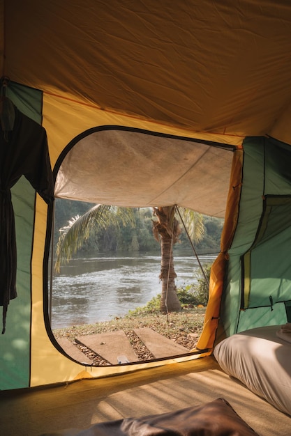 Inside of large comfortable camping tent on campground in the tropical forest by riverside on vacation