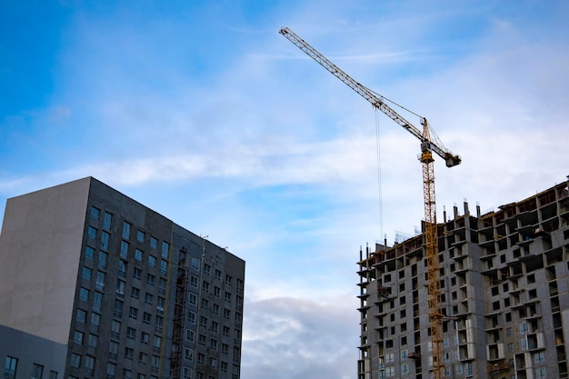 Inside place for many tall buildings under construction and cranes under a blue sky.