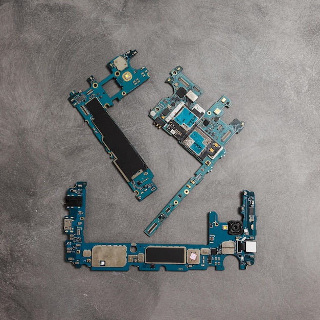 The inside of the smartphone's motherboard and tools lay on the back table. the concept of computer hardware, mobile phone, electronic, repairing, upgrade and technology.