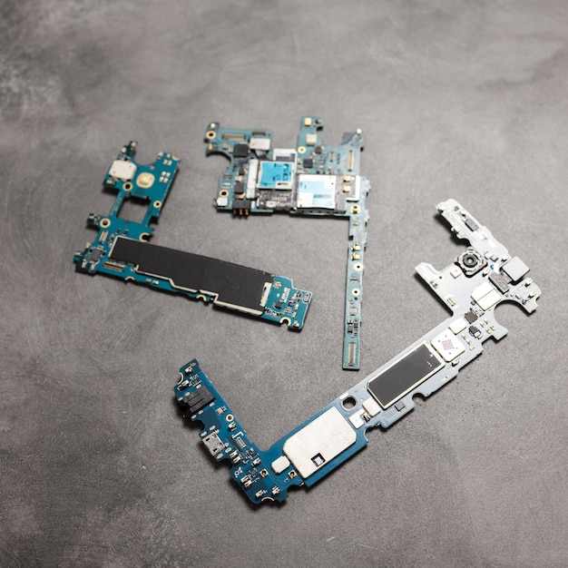 The inside of the smartphone's motherboard and tools lay on the back table. the concept of computer hardware, mobile phone, electronic, repairing, upgrade and technology.