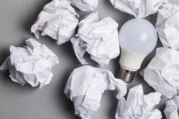 Inspiration and imagination concept lightbulb with white crumpled paper documents