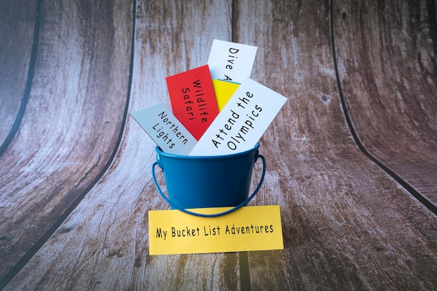 Inspirational and conceptual - âMy bucket list adventures â written on a colorful paper inside of a blue bucket