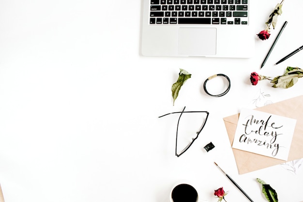 Inspirational quote "Make Today Amazing" written in calligraphic style on paper with red roses, laptop, coffee on white surface