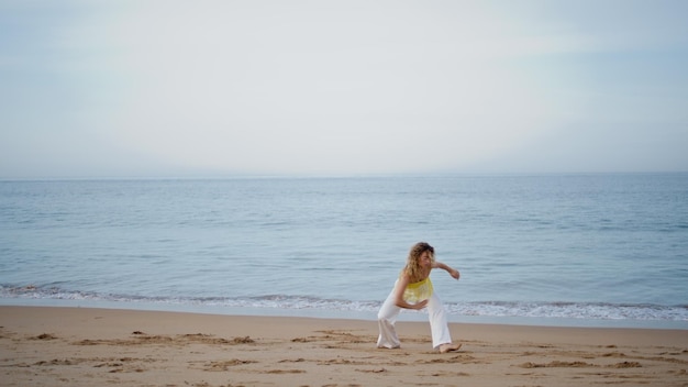 Inspired choreographer woman dancing at empty sea coast girl dancer moving body