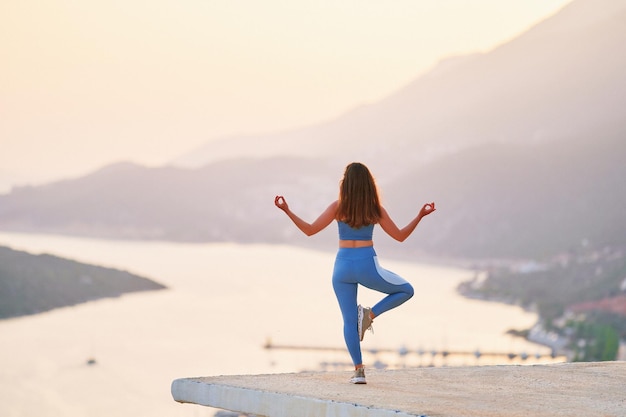 Inspired female enjoying of meditation on top with beautiful view at sunset time Relief stress and clean healthy minds