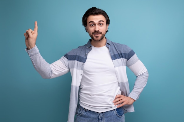 Inspired young man pointing his finger to the side demonstrating the presence of a strategy