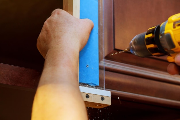 Installation of furniture hinges on the cabinet door master drills the door in the cabinet door