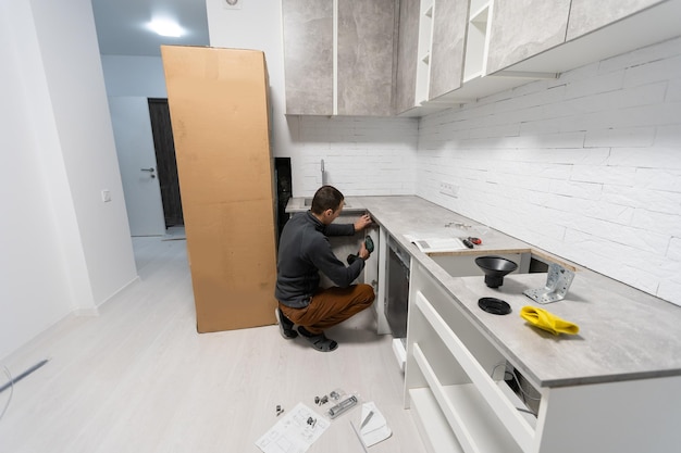 Photo installation hoses for dishwasher machine domestic connection plumbing pipes in kitchen