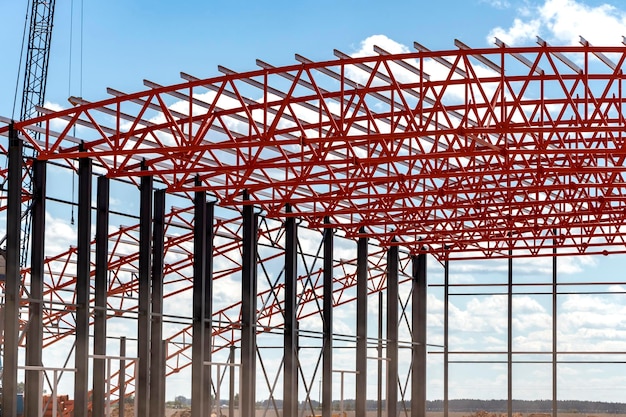 Installation of metal trusses and frame during the construction of an industrial building or factory The work of installers during the installation of the roof Construction of a large frame shop