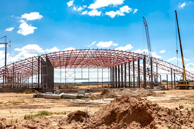 Installation of metal trusses and frame during the construction of an industrial building or factory The work of installers during the installation of the roof Construction of a large frame shop