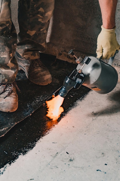 Installation of waterproofing coating on the floor with a blowtorch and resin