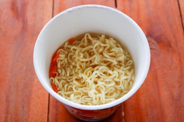 Instant noodles boiled cook instant ramen noodles in a cup noodle soup on paper bowl