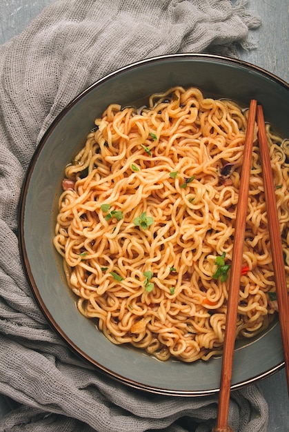 Instant noodles in a bowl on a gray table top view no people