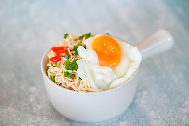 Instant noodles cooking tasty eating with bowl noodles bowl with boiled egg vegetable spring onion and chili on table food noodle soup