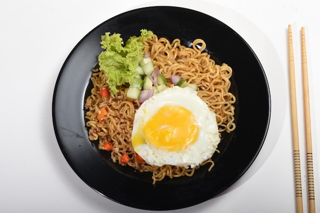 instant noodles with fried eggs, pickles and vegetables. delicious and spicy.