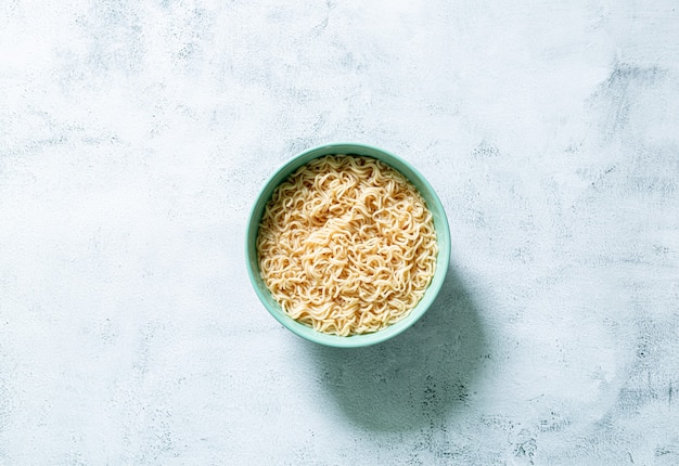 instant noodlesConcept of tasty eating with bowl of noodles on gray background