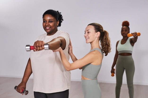 Instructor training overweight woman in gym