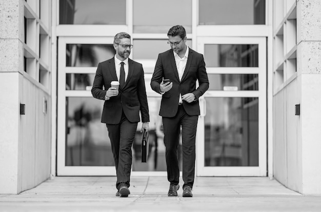 Photo insurance agent two business team men man in suit walking across on american office outdoor