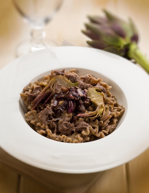 Integral pasta with artichoke and chicory selective focus