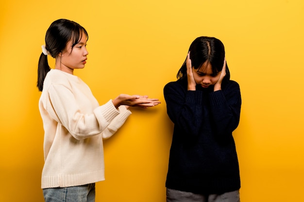 The intensity of communication misunderstanding Two friends don't talk to each other after a fight behind the yellow background Filming of content about conflicts and misunderstandings