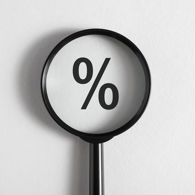 Photo interest rate size financial concept closeup magnifying glass focused on percentage sign on white background