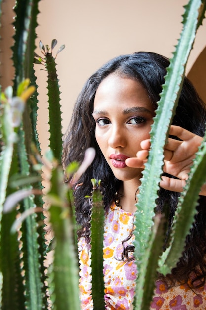 Interested cute girl peeking through plants