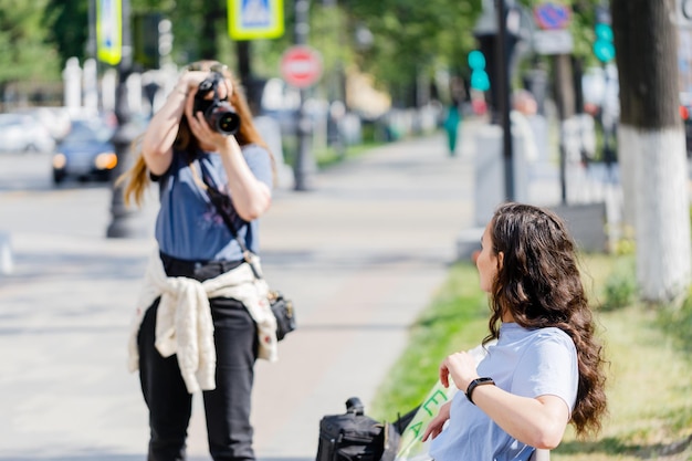 Interested female photographer working on the street Outdoor photo of woman photographer with camera