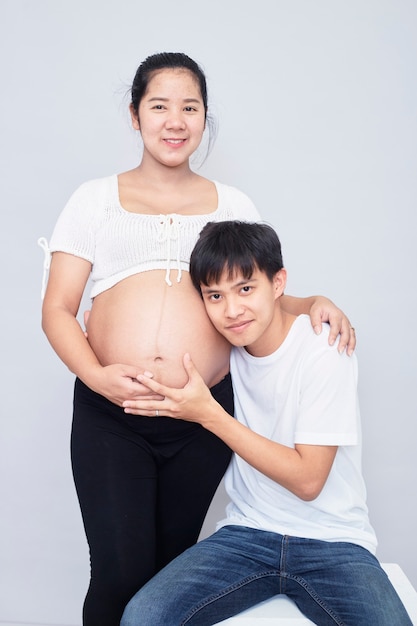 Interesting Asian couple, happy pregnant mother and father isolated on white surface, International family day