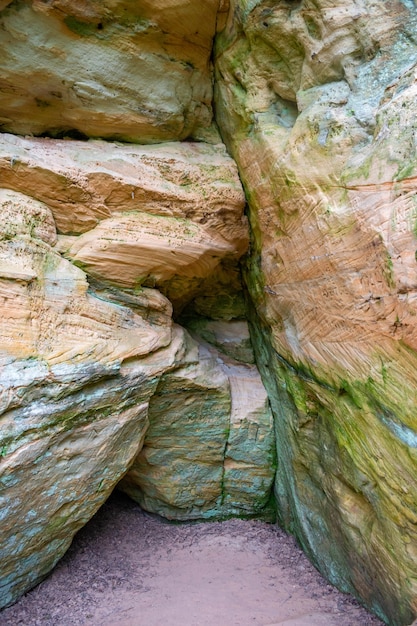 Interesting cave in licu  lange rock latvia fragment of sandstone cliff in forest in sunny day