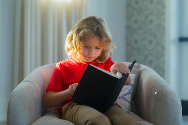 Interesting kids book story Kid boy reading book at living room