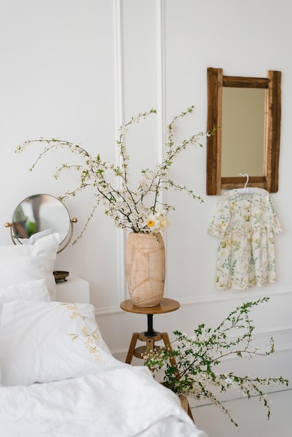 The interior of a beautiful white modern bedroom with spring flowers