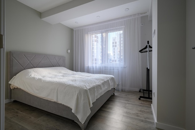 Interior of bright white bedroom with double bed