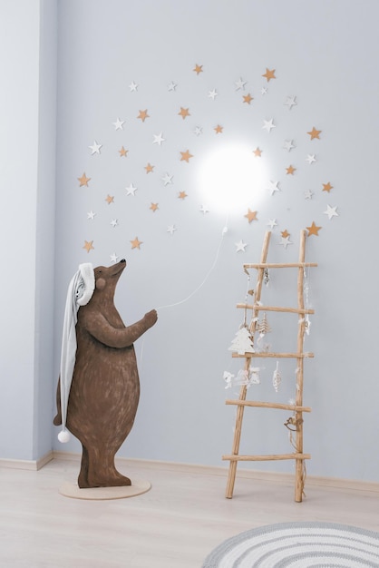 The interior of the children's room decorated for Christmas The bear holds a balllamp in his hands Creative home decor