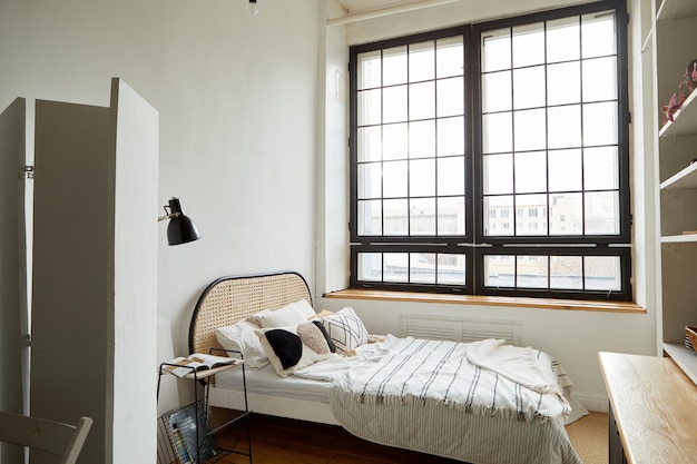 Interior of contemporary bedroom with new comfortable bed and wooden shelves in flat designed in minimal style