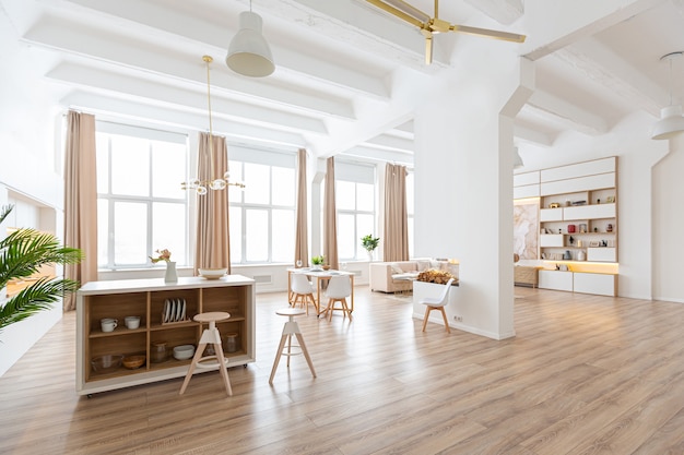 Interior design spacious bright apartment in Scandinavian style and warm pastel white and beige colors. trendy furniture in the living area and modern details in the kitchen area.