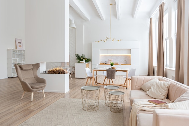 Interior design spacious bright apartment in Scandinavian style and warm pastel white and beige colors. trendy furniture in the living area and modern details in the kitchen area.