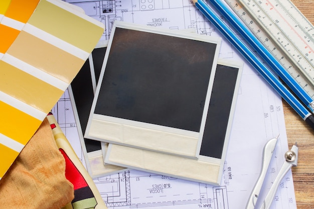 Interior designer's working table, an architectural plan of the house,  color palette and fabric samples in yellow shades, copy space on instant empty photos