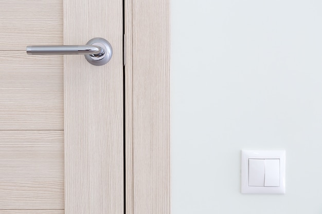 Interior detail. A door handle and a light switch 