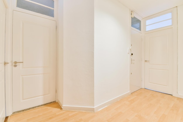 The interior of an empty light corridor with doors and parquet floor