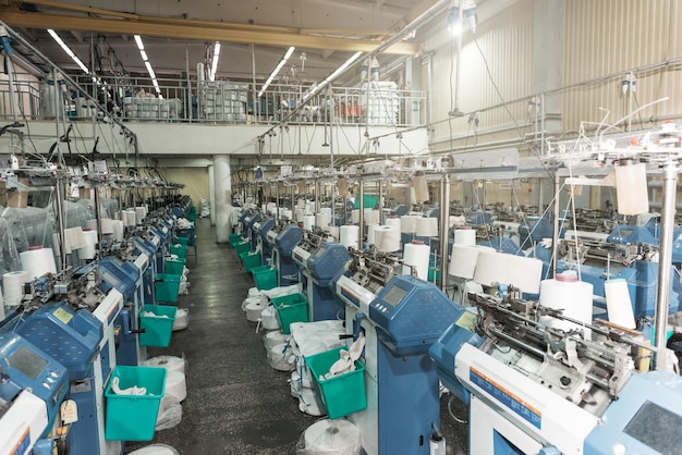 Interior of garment factory shop textile workshop with sewing machines industry concept