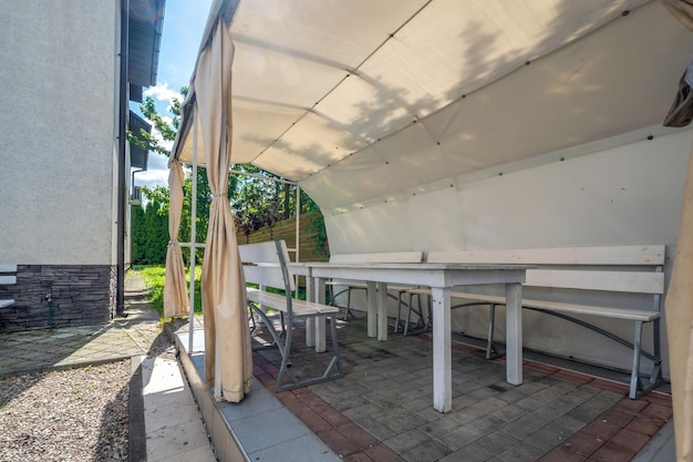 Interior of hall veranda or gazebo in wooden village vacation home with garden chairs