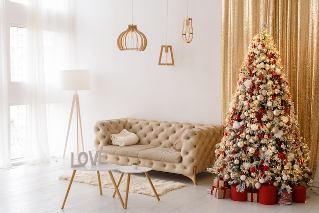 Interior living room with a sofa, table, floor lamp and panoramic window. Christmas tree