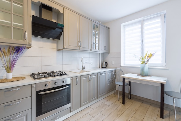 Interior of a modern beige and gray kitchen in a small smart apartment