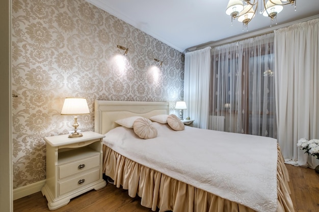 Interior of the modern luxure bedroom with pillows on the bed in studio apartments in light color style