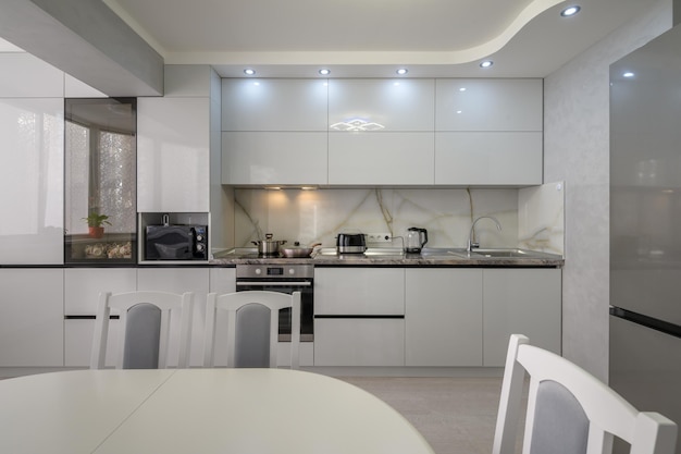 Interior of modern trendy white kitchen front view