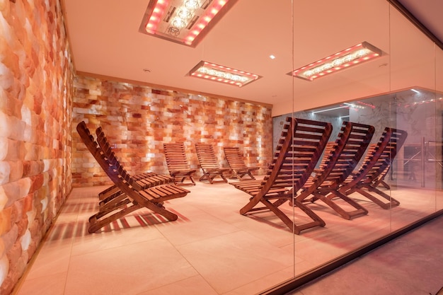 Interior of modern wellness salt haloper cave with uv light with wooden bench