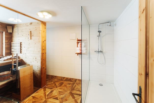 Interior of modern white bathroom with wood design. Home with mirror, sink and shower. Hotel bath room. House with towel, toilet furniture and decor. Wall and floor on background. Wooden decoration