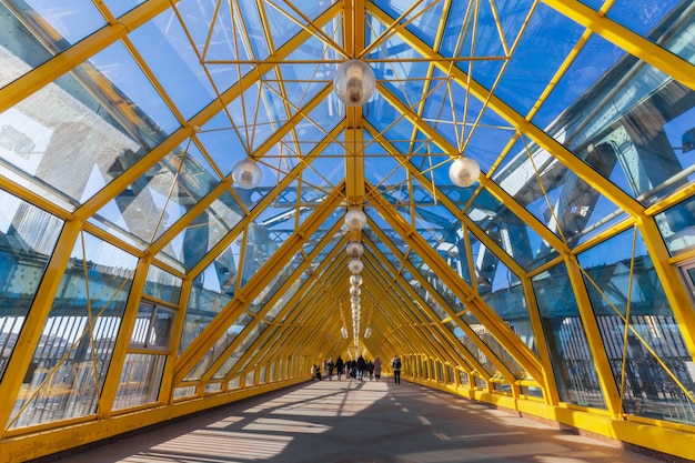 Interior of pedestrian bridge with sophisticated metal structures in contrast light Moscow Russia